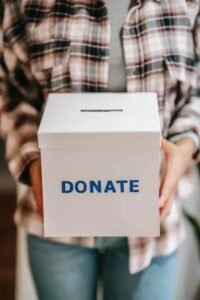 image of person holding a donate box